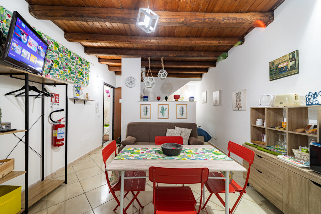 stanza con divano letto, tavolo e televisore