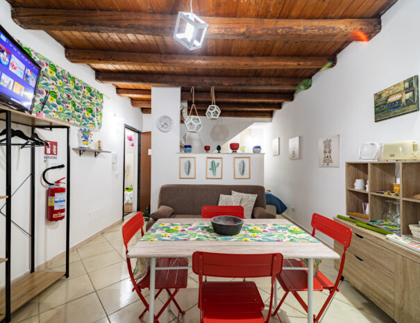 stanza con divano letto, tavolo e televisore